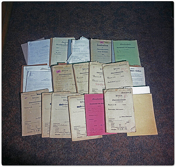 rich Mielkes "Roter Koffer", aufgenommen während einer Durchsuchung des SdM durch die Militärstaatsanwaltschaft im Dezember 1989; Quelle: BArch, MfS, HA IX, Fo, Nr. 610, Bild 68 Blick auf die auf dem Fußboden drapierten Unterlagen aus dem Roten Koffer